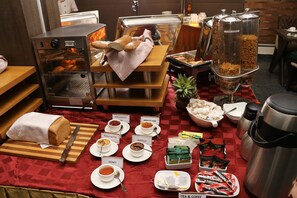 Un bufé de desayuno con diversos alimentos y bebidas.