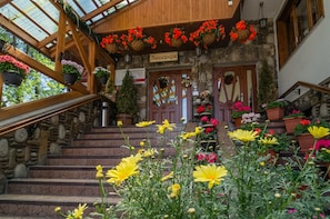 A stone building with a wooden staircase leading to a reception area. - Willa Roztoka (Bukowina Tatrzanska)