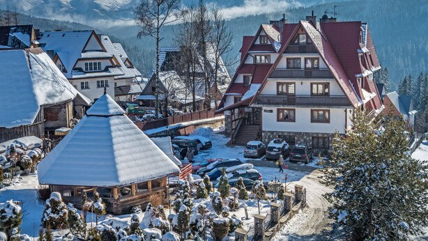 A traditional Alpine village with snow-covered buildings and a mountainous backdrop. - Willa Roztoka (Bukowina Tatrzanska)