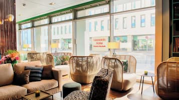 Vestíbulo de hotel con muebles de mimbre, un sofá y una mesa de centro.