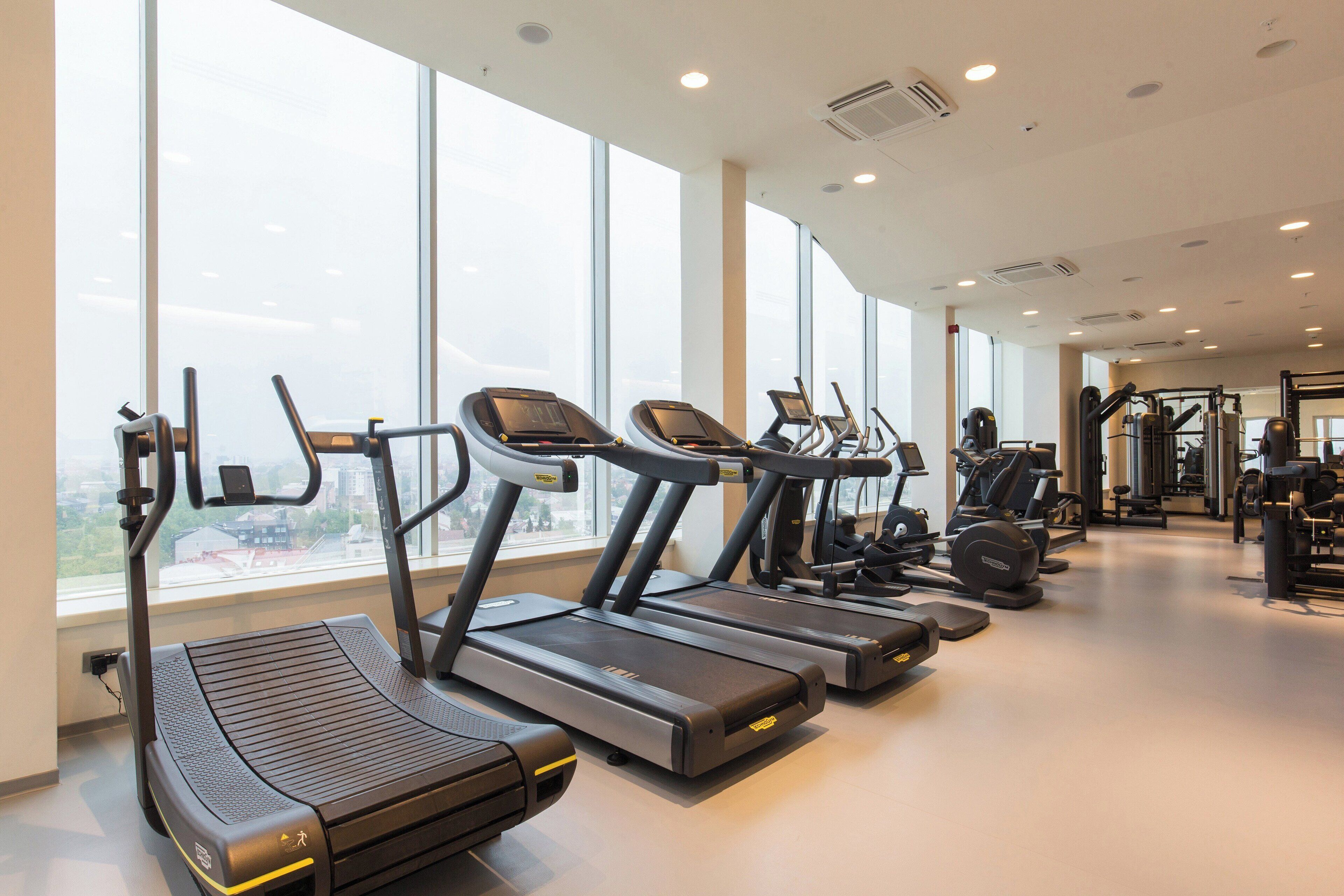 A gym with treadmills, exercise bikes, and weight machines.