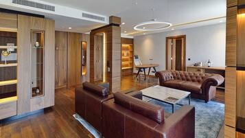 A modern living room with a leather sofa, a coffee table, and built-in wooden shelving.