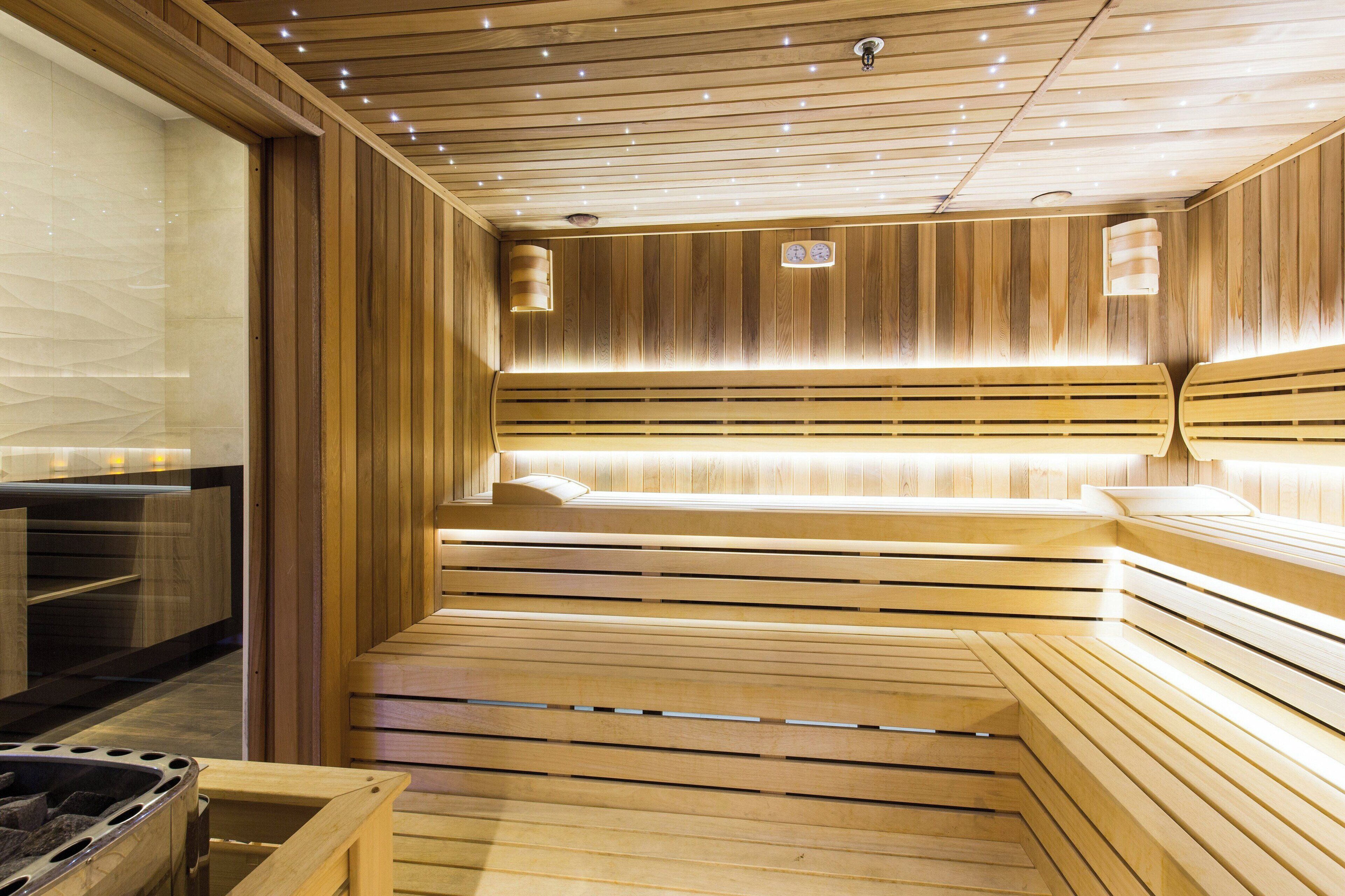 A sauna with wooden benches and a glass wall.