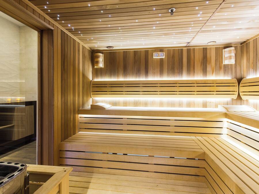 A sauna with wooden benches and a glass wall.