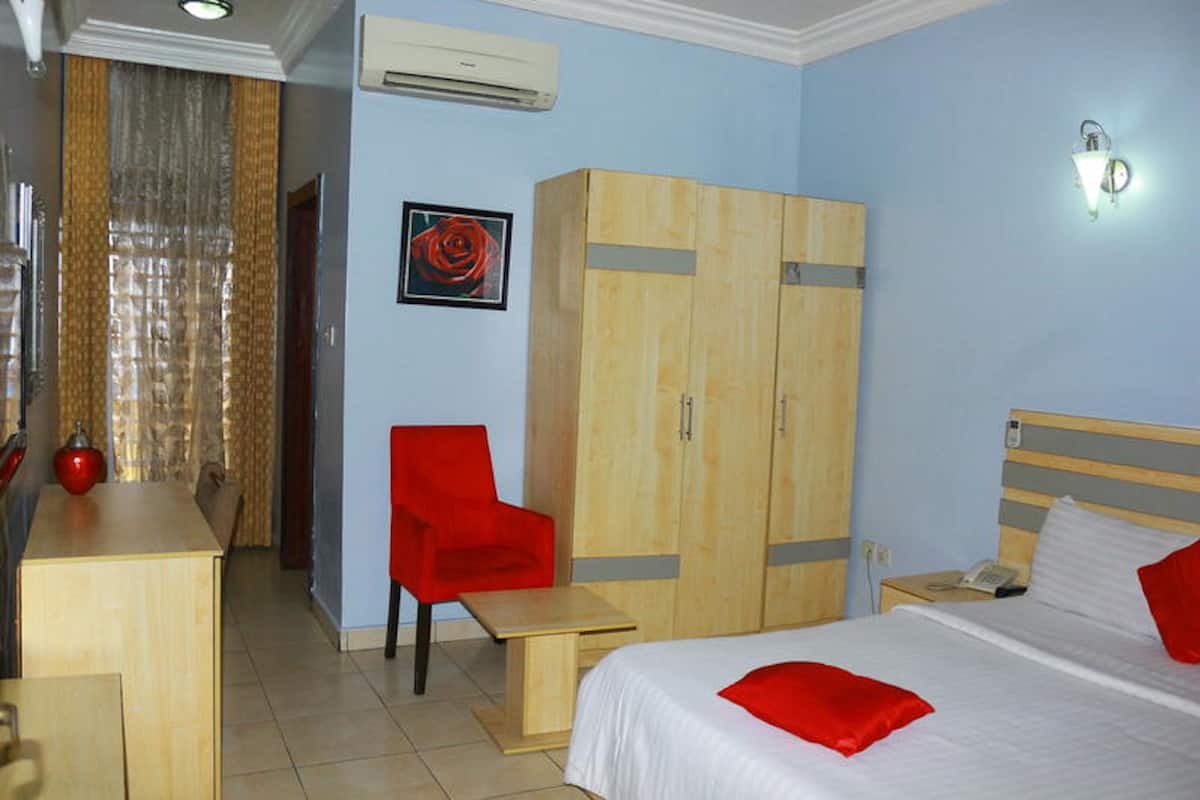 Een hotelkamer met een bed, een bureau, een stoel, een kledingkast en een badkamer.