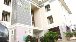 Un edificio de varios pisos con un llamativo logotipo verde en la fachada.