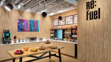 Interior moderno de café com decoração em madeira, máquina de café, quadro de menu e mesa com doces.