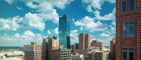 A city skyline with a variety of building heights and architectural styles, including a prominent glass skyscraper.