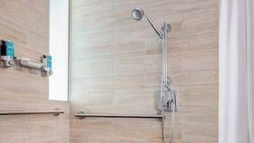 Una ducha moderna con cabezal de ducha manual, grifo empotrado y panel de control.