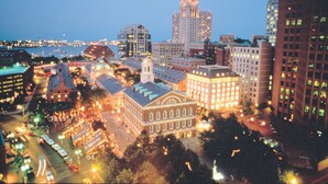 A cityscape at dusk with illuminated buildings and a river in the background. - Courtyard by Marriott Boston Downtown/North Station (Boston)