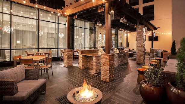 A spacious indoor patio with a fire pit, wooden pergola, and comfortable seating areas. - Homewood Suites by Hilton Louisville Downtown, KY (Louisville)