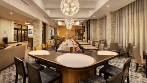 A spacious hotel lobby with a central seating area, stone accent walls, and a chandelier. - Homewood Suites by Hilton Louisville Downtown, KY (Louisville)