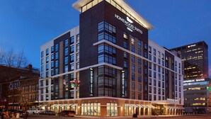 A modern hotel with multiple floors, large windows, and a prominent sign for Homewood Suites. - Homewood Suites by Hilton Louisville Downtown, KY (Louisville)