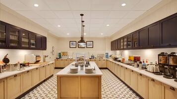 A spacious kitchen with a central island, equipped with various appliances and utensils.
