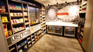 Un espace dédié à la présentation des en-cas et des produits sucrés, avec des étagères remplies de divers en-cas et une section réfrigérée.