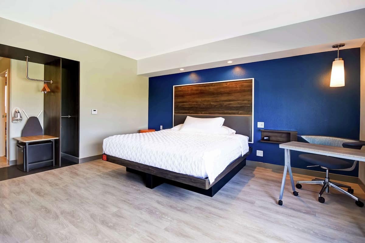 Una habitación de hotel moderna con una cama grande, un escritorio y una silla.