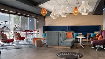 Uma sala de estar moderna com cadeiras suspensas, um sofá e um espaço para refeições.