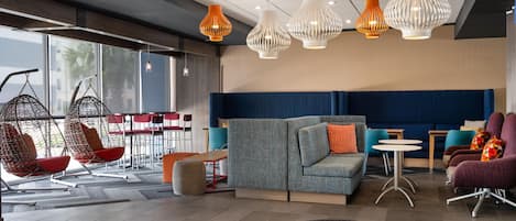 A modern lounge area with hanging chairs, a sofa, and a dining area.
