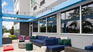 Un espace extérieur aménagé avec des canapés, des fauteuils et un foyer.