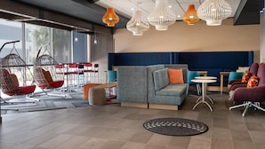 Un espace de détente moderne avec des fauteuils suspendus, un canapé et un coin repas.