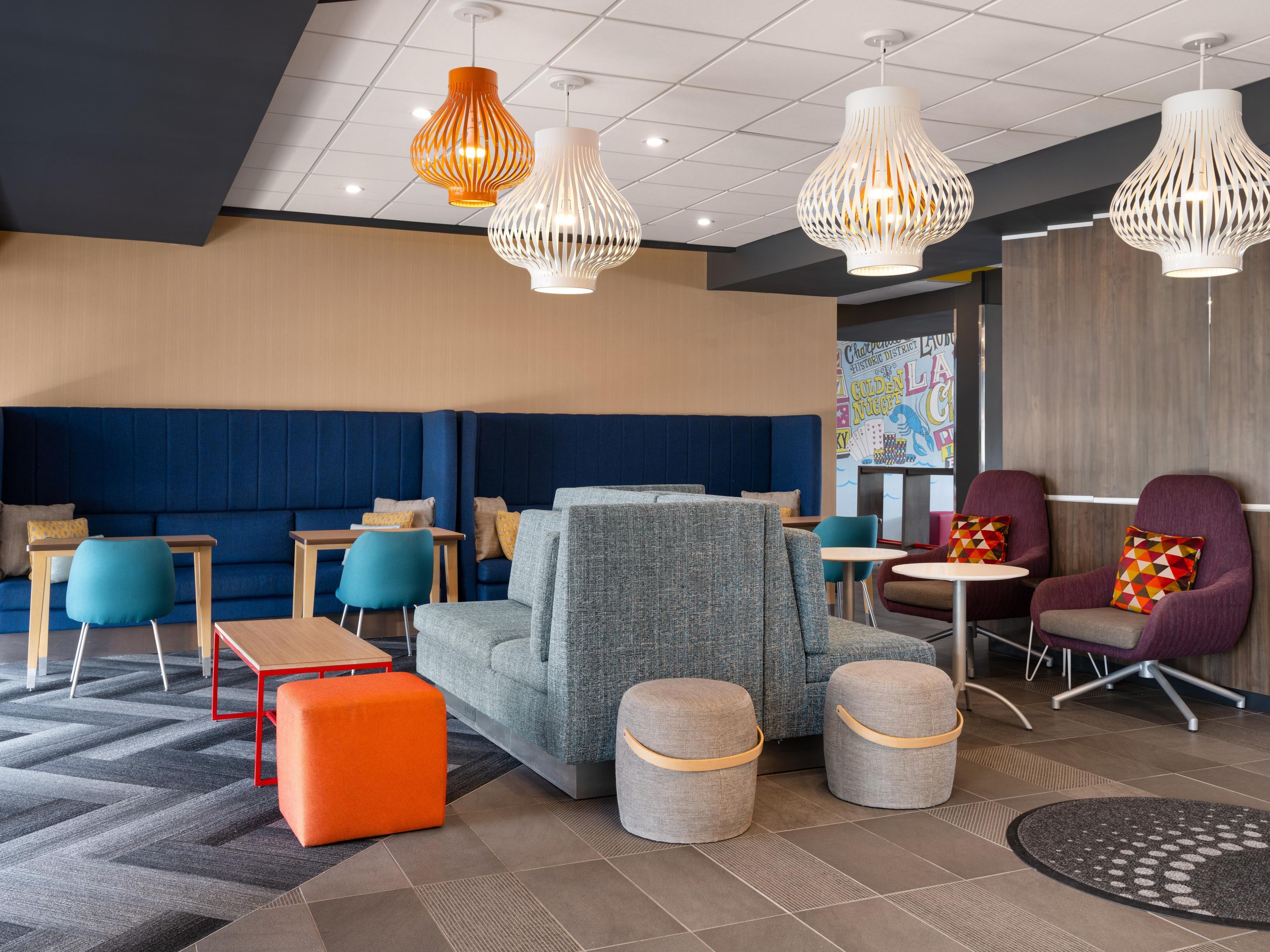 Un espace lounge moderne doté de sièges, de tables et d’un éclairage original, avec des suspensions décoratives.