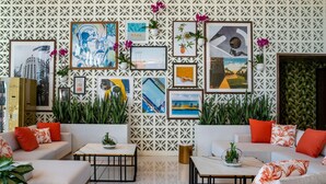 A modern living room with white sofas, orange cushions, and a geometric patterned wall. - Element by Marriott Fort Lauderdale Downtown (Fort Lauderdale)