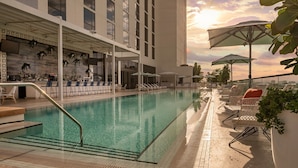A rooftop pool area with a bar, lounge chairs, and umbrellas. - Element by Marriott Fort Lauderdale Downtown (Fort Lauderdale)