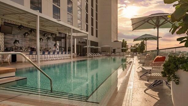 A rooftop pool area with a bar, lounge chairs, and umbrellas. - Element by Marriott Fort Lauderdale Downtown (Fort Lauderdale)