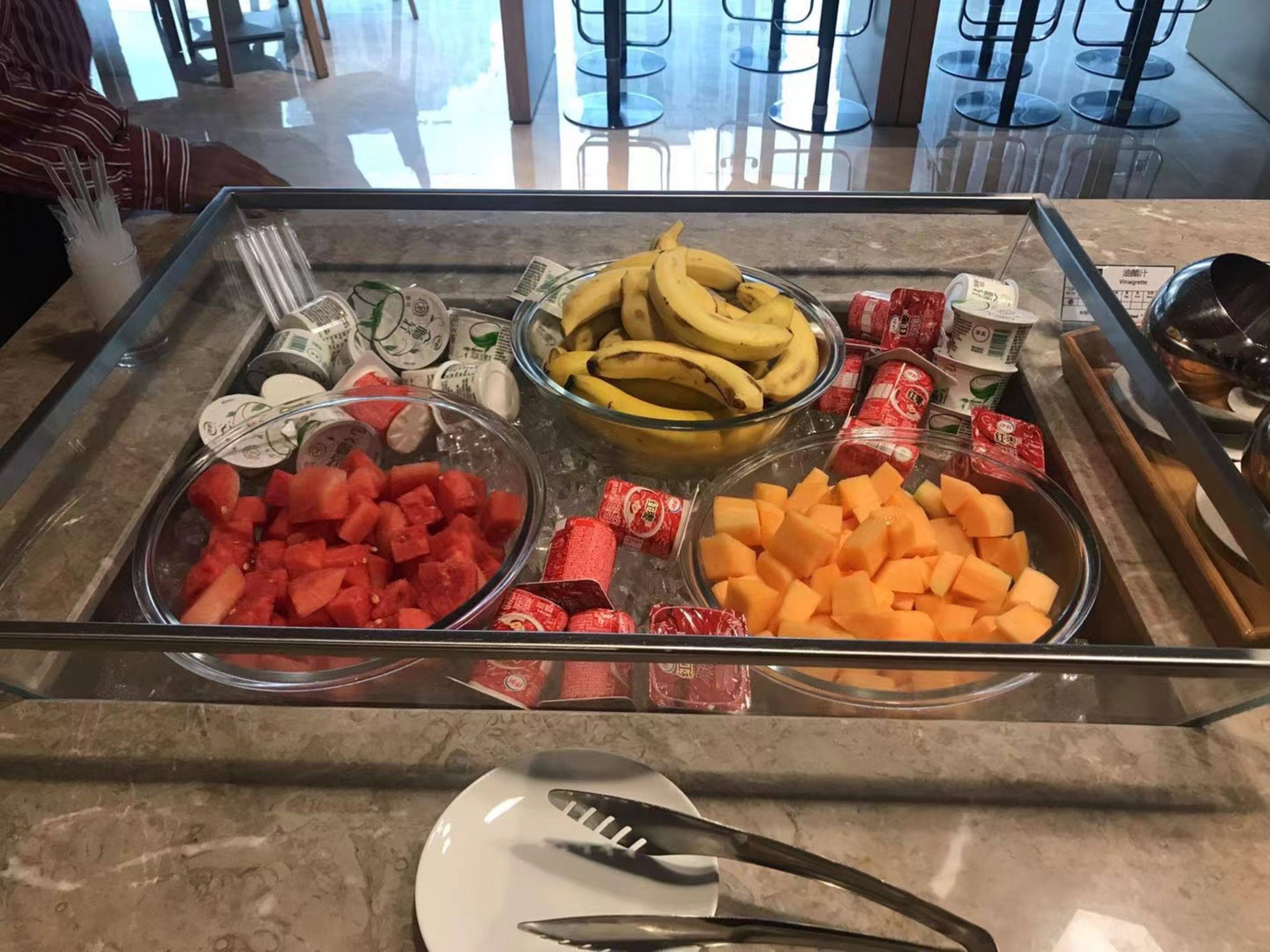 Buffet com diversas frutas e acompanhamentos.