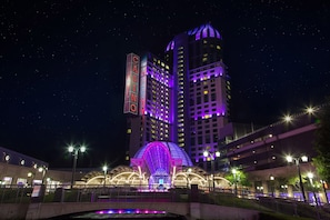 A high-rise building with illuminated signage and a distinctive arched structure at its base. - Holiday Inn Express Niagara-On-The-Lake by IHG (Niagara-on-the-Lake)