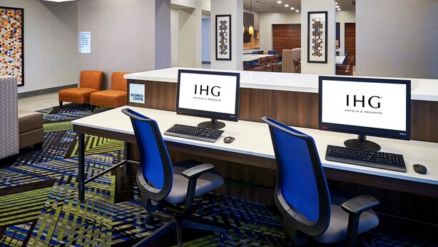 A business center with two computer workstations, a reception desk, and a seating area with orange chairs. - Holiday Inn Express Niagara-On-The-Lake by IHG (Niagara-on-the-Lake)