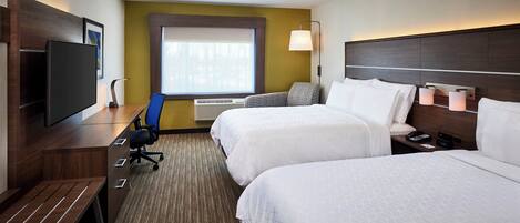 A hotel room with two beds, a desk with a chair, a television, and a window with blinds.