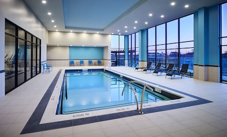 Una piscina techada, sillones reclinables de piscina