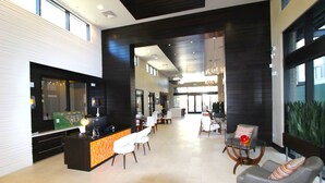 Un vestíbulo moderno con una recepción, zona de estar y un amplio ventanal.
