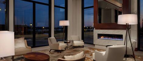 A modern living room with a fireplace, large windows, and contemporary furniture.
