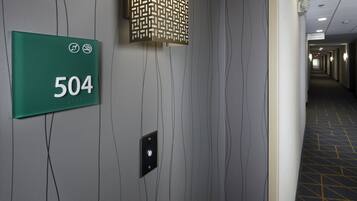 A hallway with a green sign indicating room number 504, a patterned light fixture, and a patterned floor.