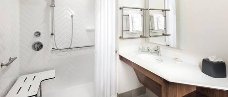 A modern bathroom with a shower, a sink with a mirror, and a towel rack.