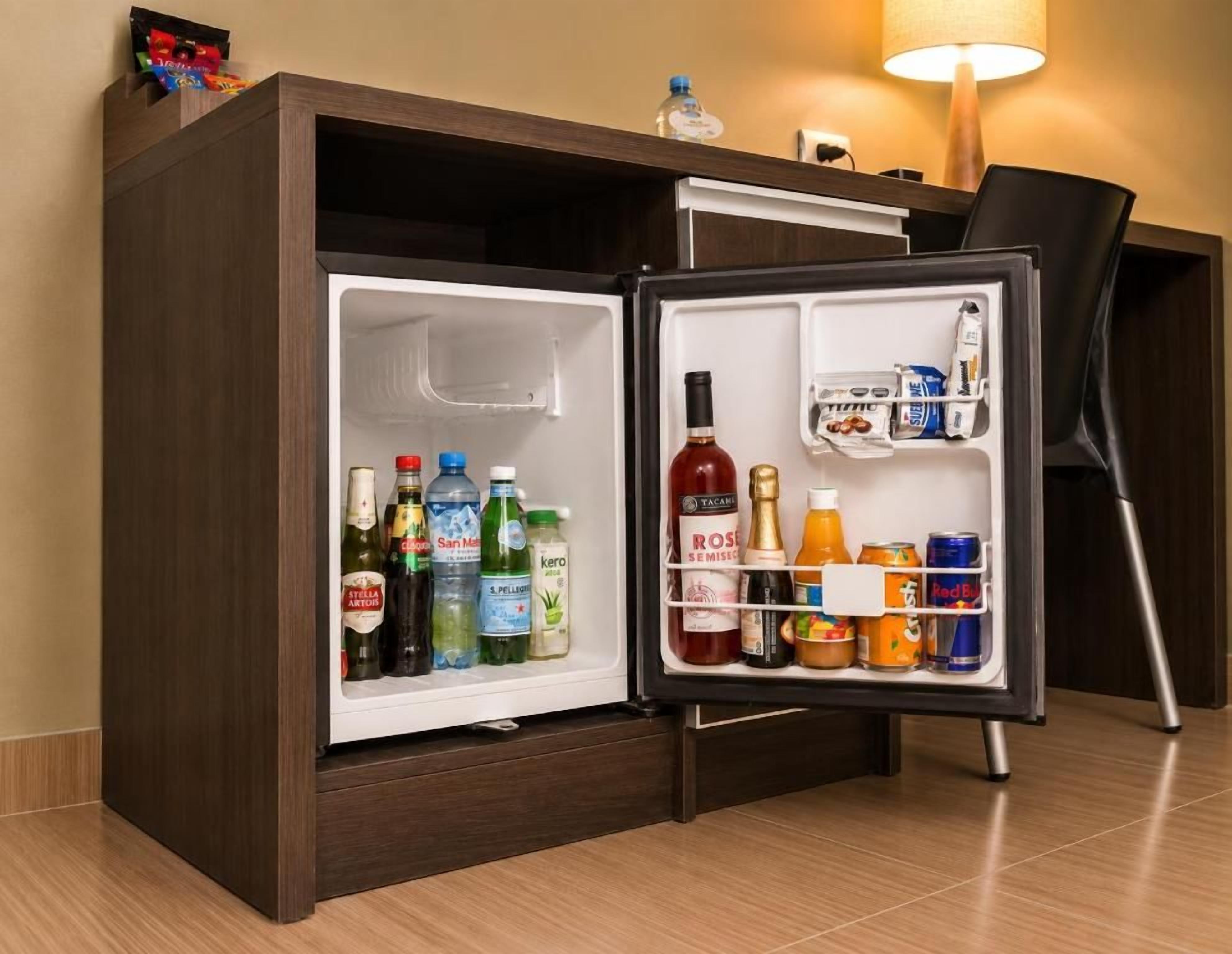 A hotel minibar with a variety of beverages and snacks.