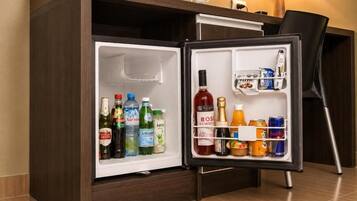 A hotel minibar with a variety of beverages and snacks.