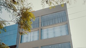 A modern hotel building with a glass facade and the name "RADO HOTELS" displayed prominently.