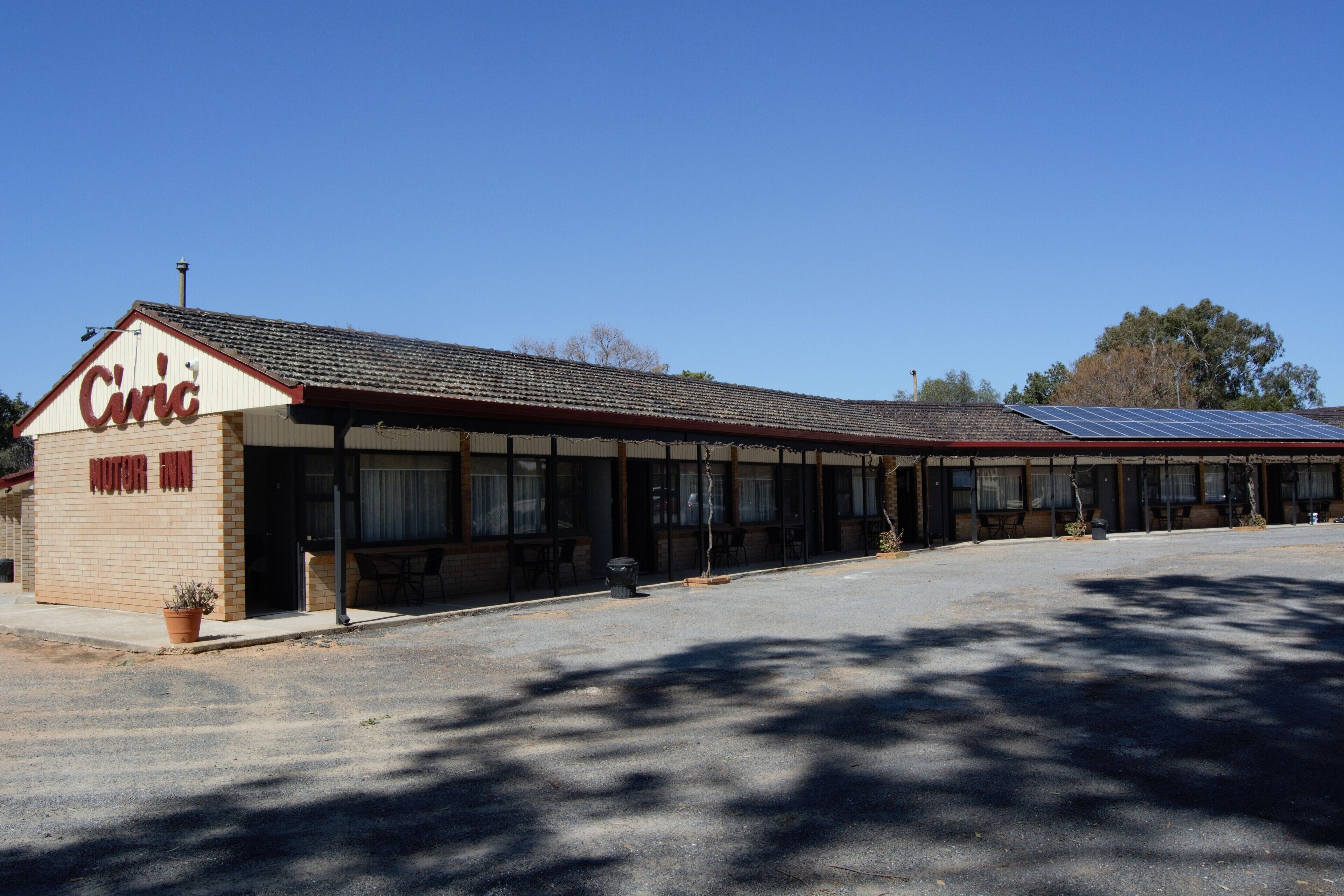 A building with a sign reading "Civic Motor Inn" and solar panels on the roof.