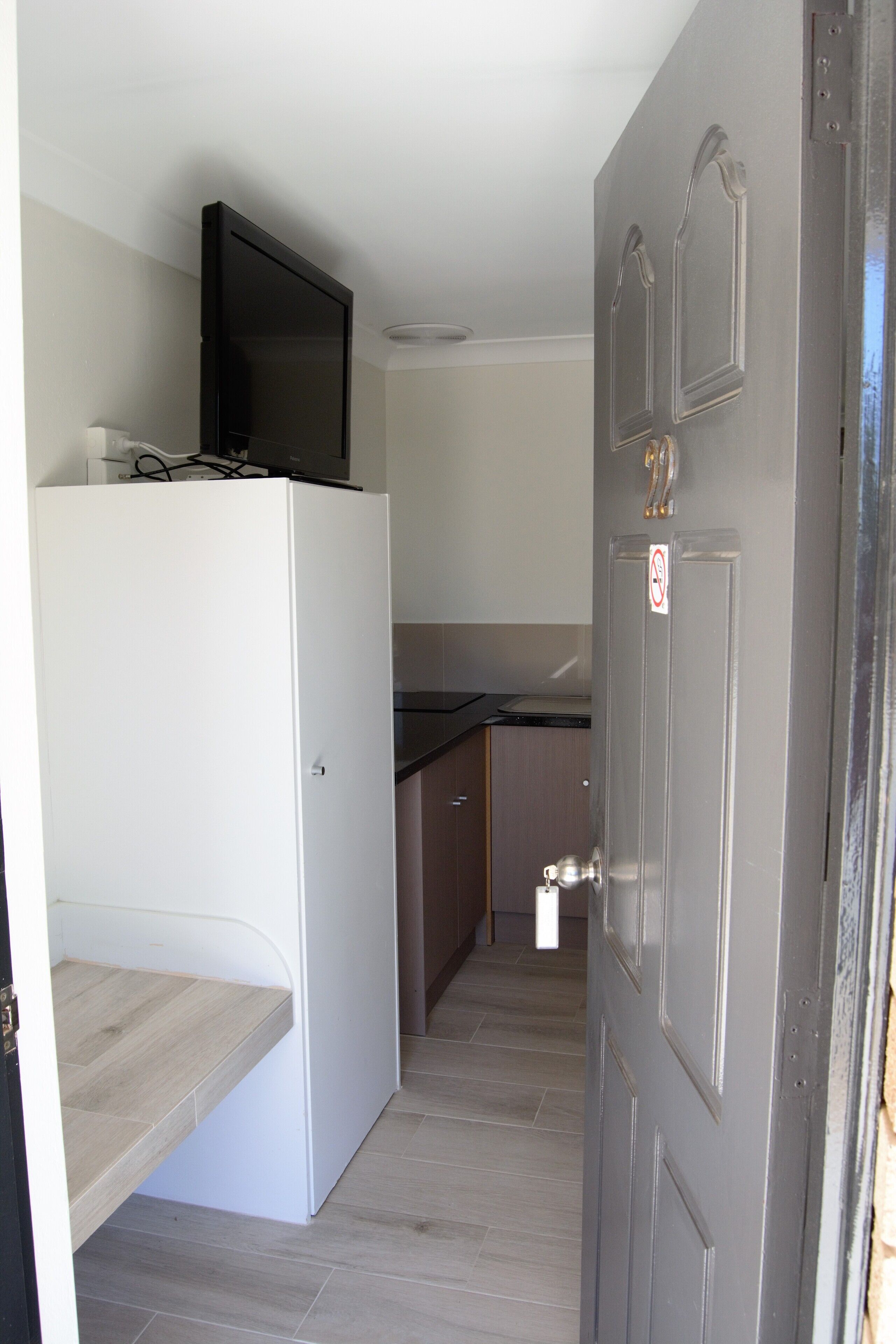 A compact kitchen with a built-in refrigerator, a microwave, and a small countertop.