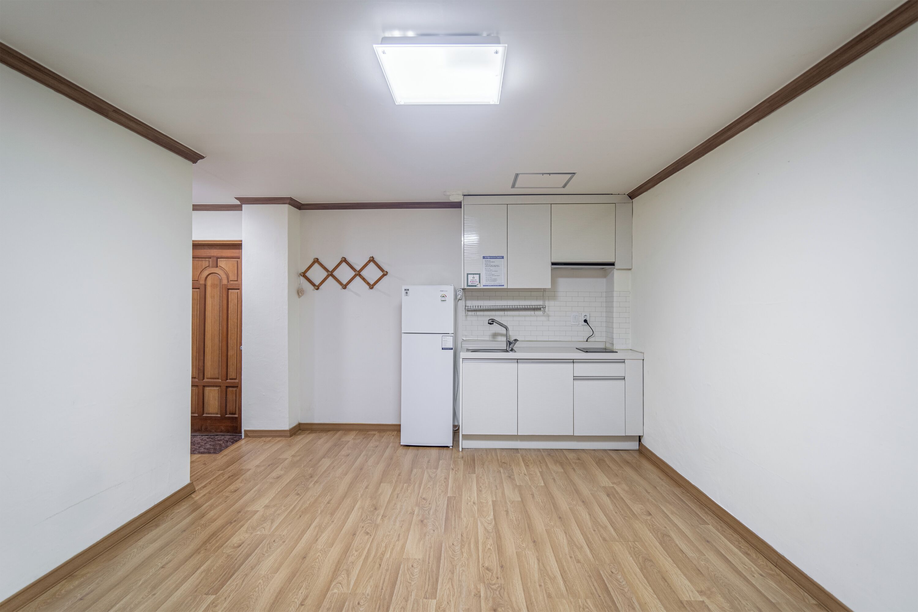 A kitchen with white cabinets, a built-in oven, and a wooden floor.
