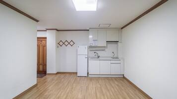 A kitchen with white cabinets, a built-in oven, and a wooden floor.