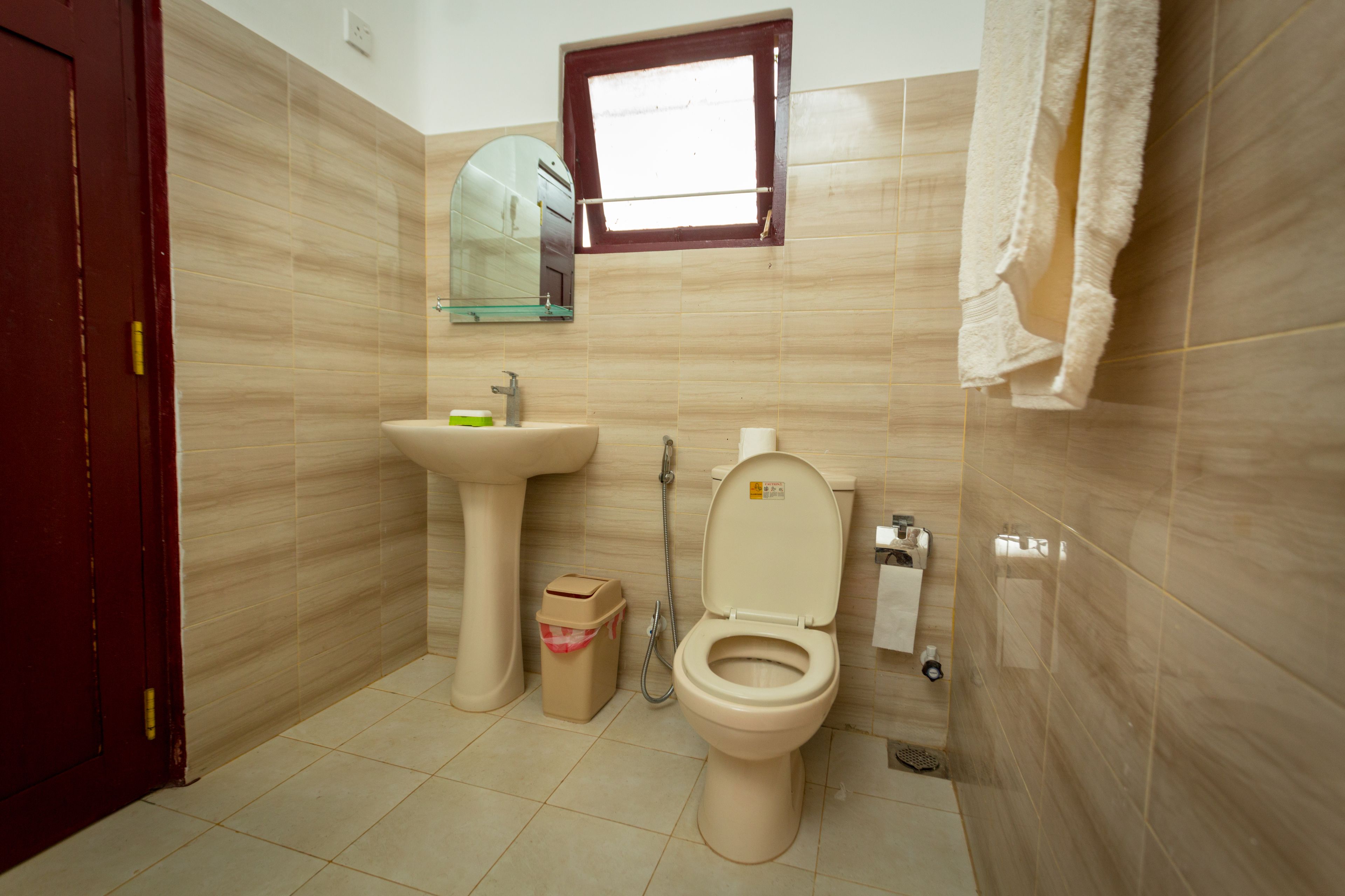 A bathroom with a toilet, sink, and mirror.