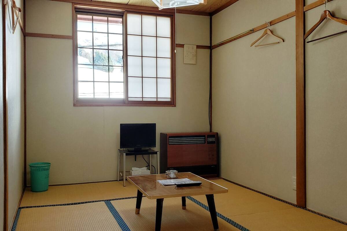 Perinteinen japanilainen huone, jossa on tatamimatto, televisio, radio ja ikkuna, josta on näkymä ulos.