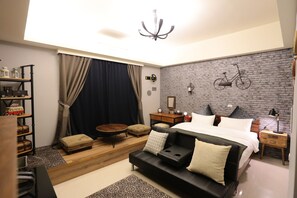 A modern bedroom with a bed, a sofa, a small table, and a bookshelf. - Aria2 home (Hualien City)