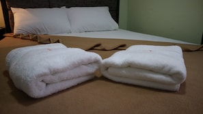 A neatly made bed with white pillows and a brown blanket. - Doniti Suites and Events Place (Mandaluyong)