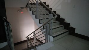 A staircase with metal railings and a red light on the wall. - Doniti Suites and Events Place (Mandaluyong)