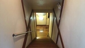 A wooden staircase with a handrail leading to a landing. - Kinreisou (Hakone)